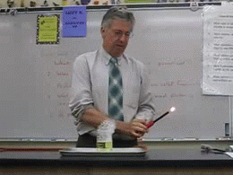 Gif d'un professeur qui fait une réaction chimique et fait naître une flamme dans sa main