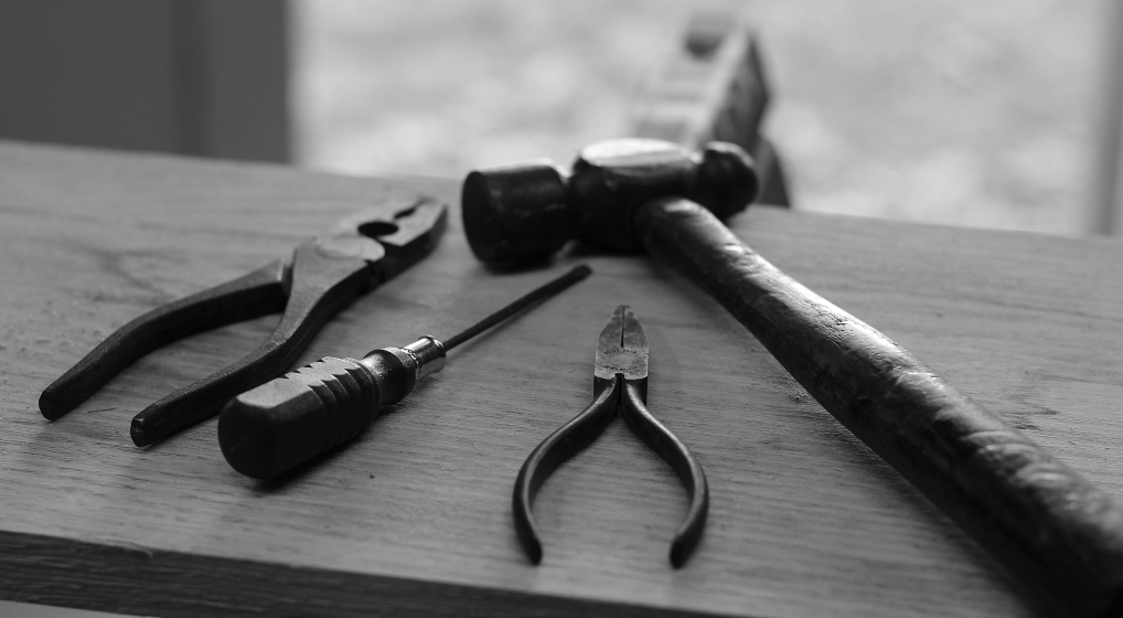 Des outils (pinces, tournevis, marteau) posés sur une planche pour illustrer l'idée de multitasking